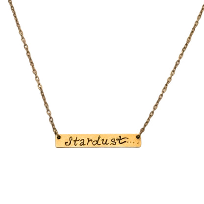 Gold necklace with 'Stardust' pendant on a white background