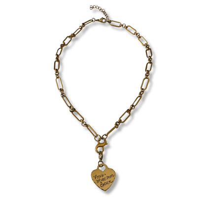 Gold chain necklace with a heart-shaped pendant on a white background