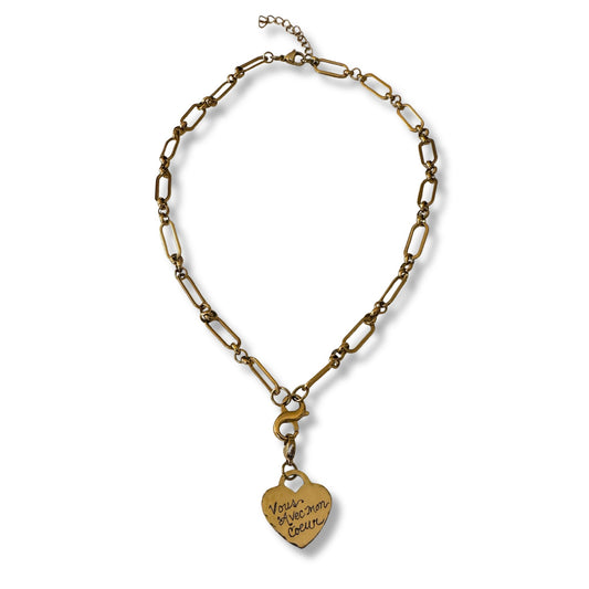 Gold chain necklace with a heart-shaped pendant on a white background