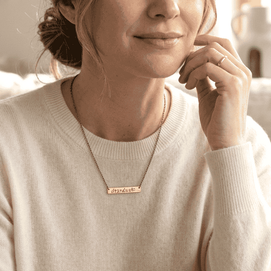 model wearing bar necklace with script stardust