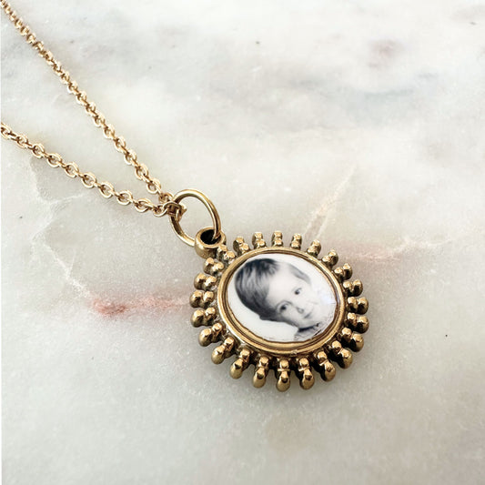gold sunburst charm featuring a photo on a dainty chain